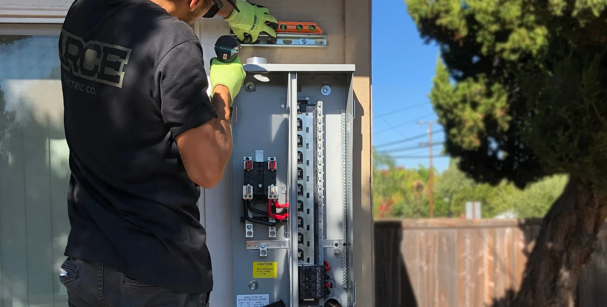 An Arce electrician wiring a new breaker panel